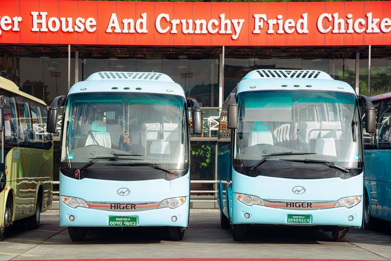 Two sky-blue Higer coaches, front on